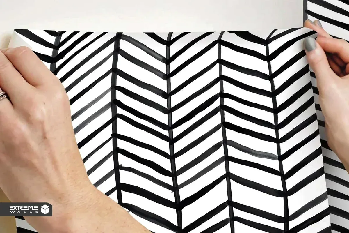 کاربردی ترین روش های ترمیم کاغذ دیواری پاره شده و آسیب دیده 16 دست در حال صاف کردن لبههای کاغذ دیواری برای ایجاد یک اتصال تمیز و مرتب